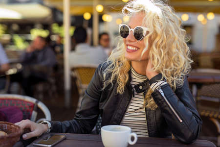 Happy and carefree woman sitting at cafeの写真素材