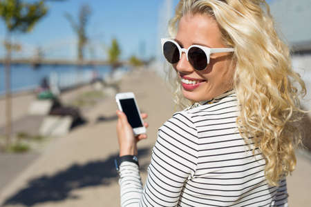 Flirty and pretty woman chatting on smartphoneの写真素材