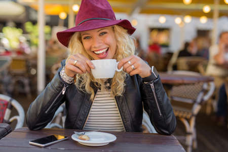 Happy woman enjoying her coffee at the cafeの写真素材