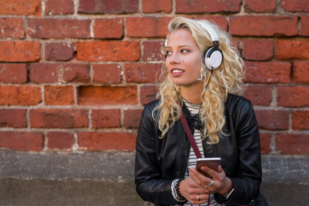 Modern woman listening to music on her smartphone