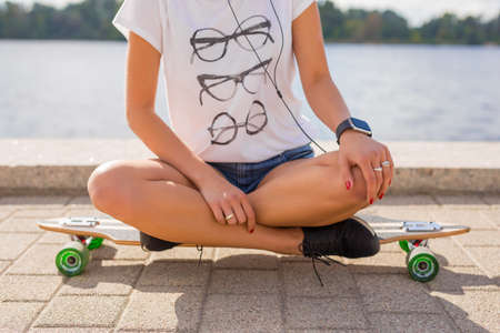 Woman in lotuss position sitting on longboardの写真素材