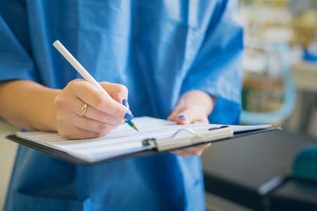 Doctor signing medical papersの写真素材