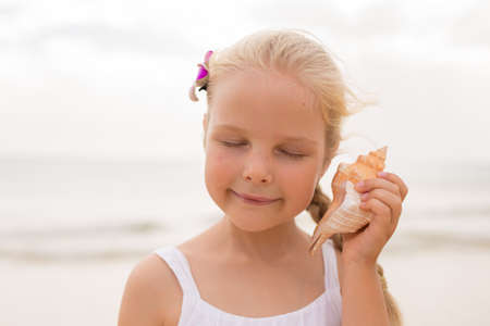 Little girl holding a seashellの写真素材