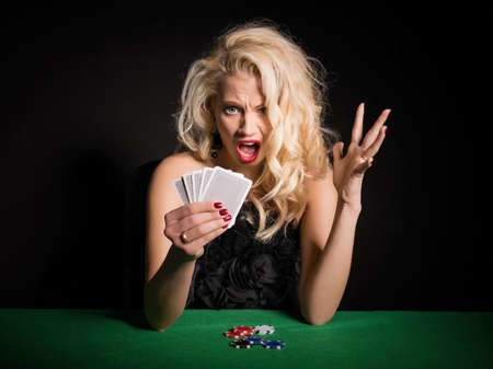 Woman in shock about her terrible deck in poker gameの写真素材