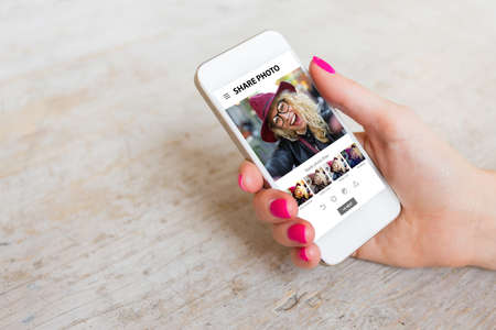 Woman using photo sharing app on phoneの写真素材