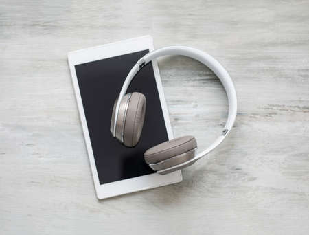 Headphones and tablet on wooden floorの写真素材
