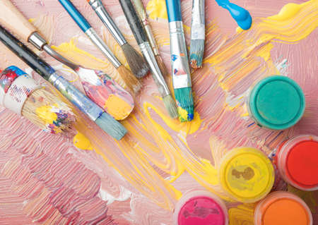 Artist paint brushes and color containers on colorful backgroundの写真素材