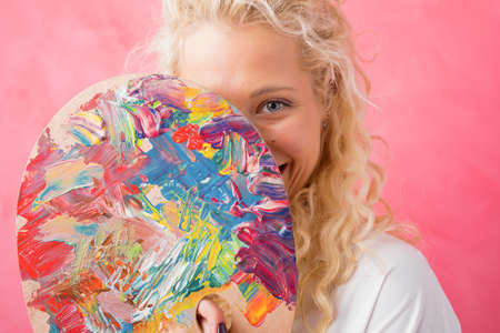 Artist hiding behind paint paletteの写真素材