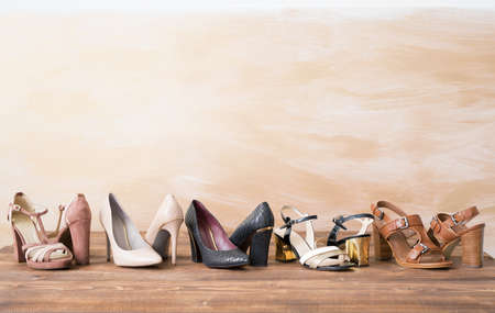 Different woman's shoes on wooden floorの写真素材