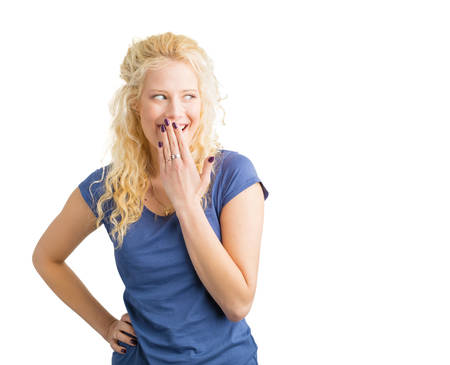 Woman giggling with her arm in front of mouthの写真素材