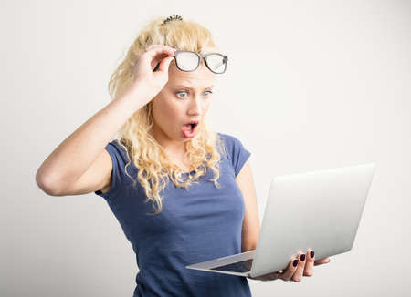 Woman in shock looking at laptopの写真素材
