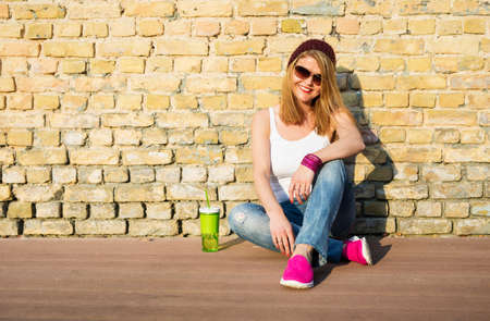 Hipster woman sitting on the groundの写真素材