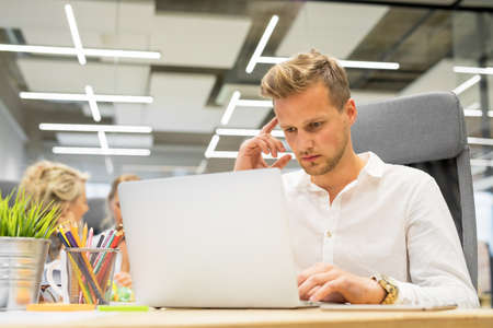 Man in office working on laptopの写真素材