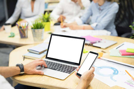 Person in office working on laptop and computerの写真素材