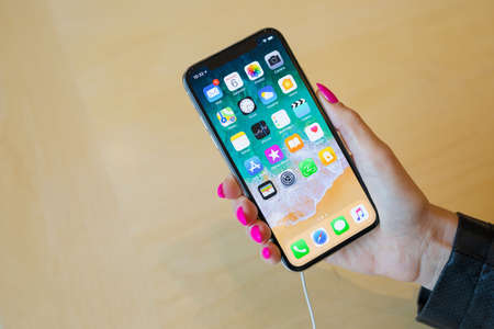 AMSTERDAM, NETHERLANDS - November 6, 2017: Girld holding iPhone X in Apple Store.のeditorial素材