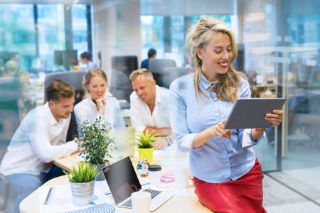 Woman working with tablet computer in officeの写真素材
