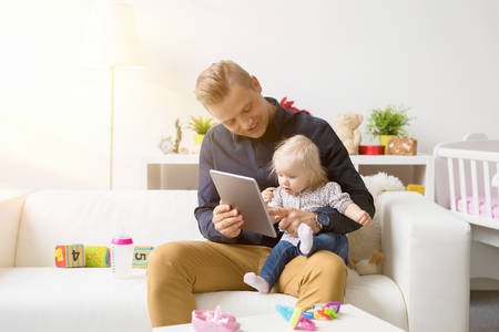 Father and daughter playing games on tablet computerの写真素材