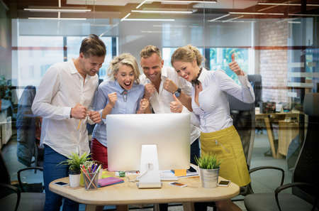 Happy business team celebrate success at workの写真素材