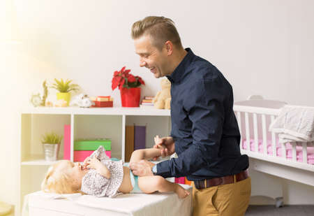 Father changing baby diapersの写真素材