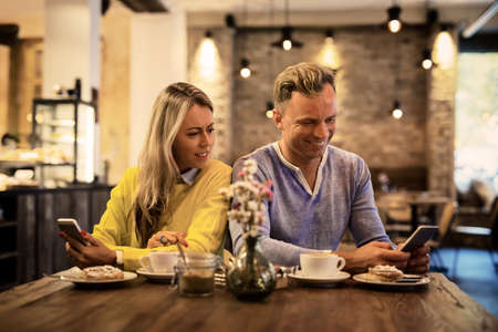 Girl looking at man's smartphone screenの写真素材