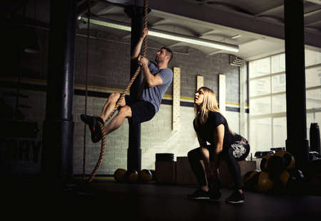 Man and woman doing exercises in gymの写真素材