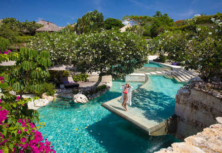 Woman relaxing in pool of luxury resortの写真素材