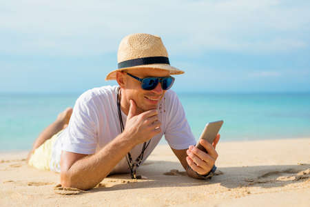 Man using mobile phone on the beachの写真素材