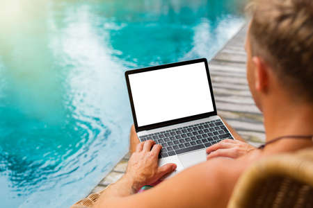 Man with laptop computer by the poolの写真素材