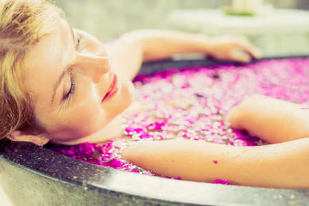 Woman relaxing in flower bathの写真素材