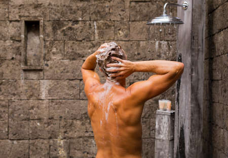 Man washing hair in outdoor showerの写真素材