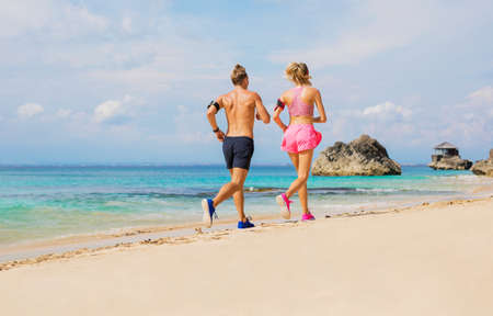 Couple running on the beachの写真素材