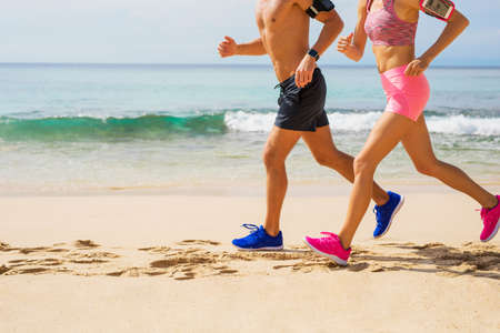 Couple running together on the beachの写真素材