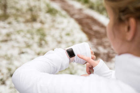 Woman working out outdoors and checking her digital watchの写真素材