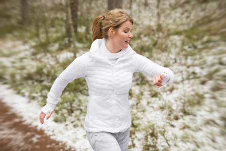Motion blurred photo of woman running outdoors in winterの写真素材