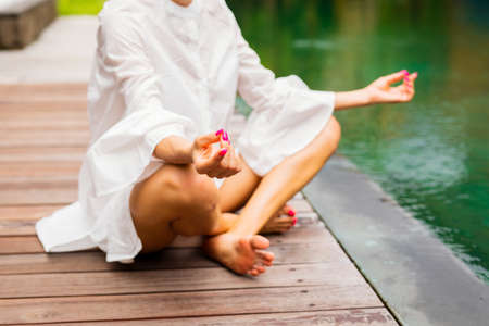 Woman meditating alone by the poolの写真素材