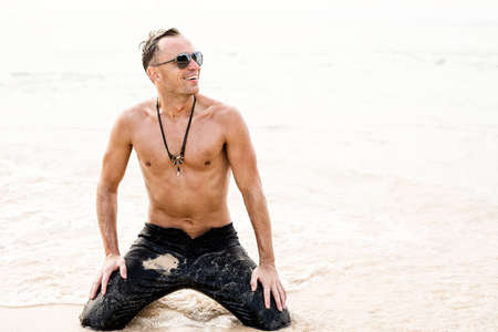 Man in wet black jeans on the beachの写真素材