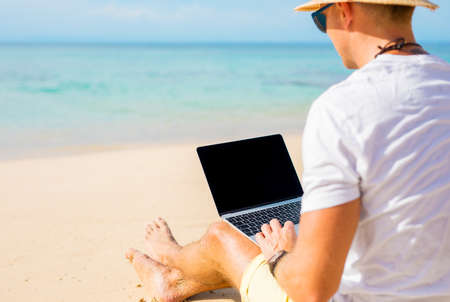 Man with laptop on the beachの写真素材