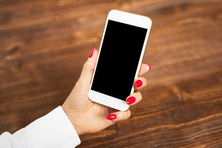 Woman holding her mobile phone in handの写真素材