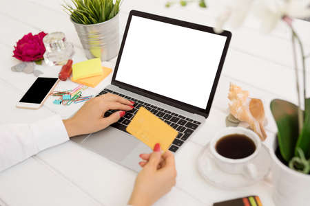 Person holding credit card in front of computerの写真素材