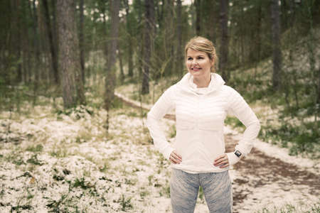 Fitness woman standing on track outdoors ready for a runの写真素材
