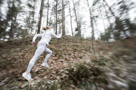 Motion blurred woman running in forestの写真素材