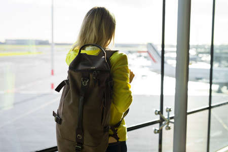 Woman with backpack walking in airportの写真素材