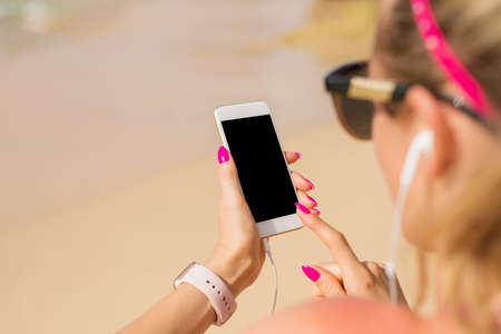 Woman using mobile phone and listen to music outdoorsの写真素材