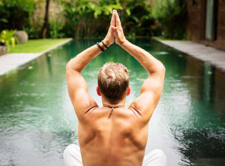 Man practice yoga by the poolの写真素材