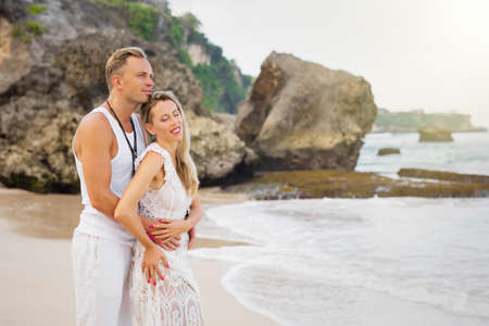 Romantic couple looking into distance by the oceanの写真素材