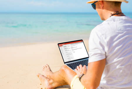 Man working with laptop on the beachの写真素材