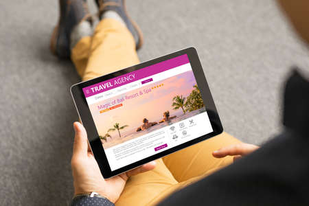 Man looking at exotic travel destinations onlineの写真素材