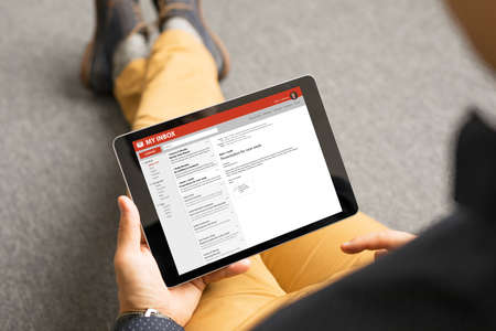 Man reading email on tabletの写真素材