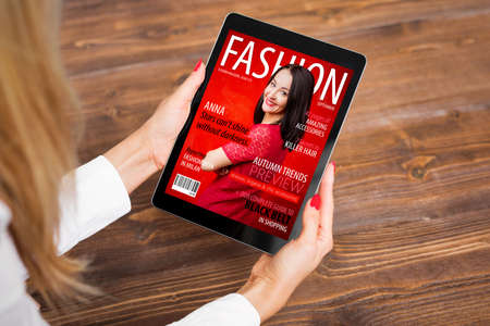 Woman reading fashion magazine on tabletの写真素材