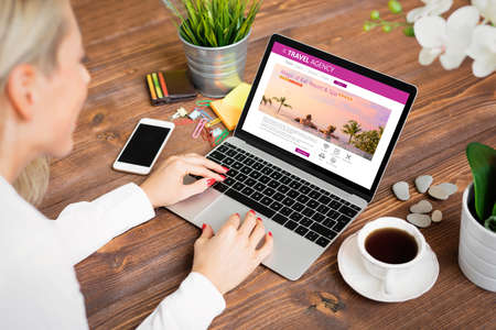 Woman looking for travel accomodationsの写真素材